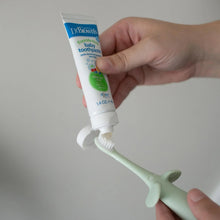 Mint elephant toothbrush with toothpaste dispensed onto white bristles