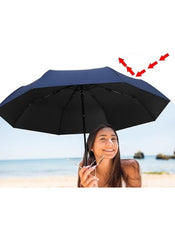 Mumzar dual purpose automatic umbrella in navy blue held by smiling woman at the beach