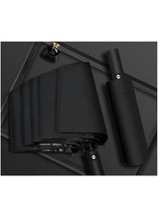 Black dual purpose automatic umbrella by Mumzar folded and unfolded on a dark surface