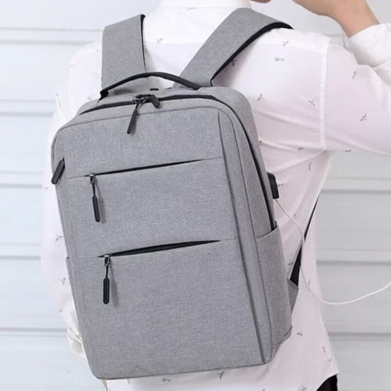 Huitich durable laptop backpack waterproof in gray worn on back with multiple zippered compartments