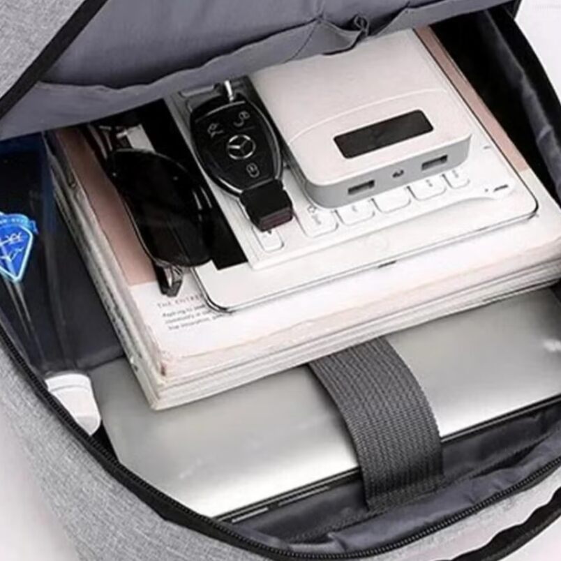Durable laptop backpack waterproof by Huitich with organized compartments holding laptop, sunglasses, keys, and gadgets