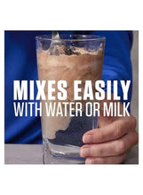 Whey protein shake mixing in water-filled glass, blue particles visible