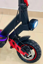 Electric scooter front-side view with headlight, black fender, and red side panel.