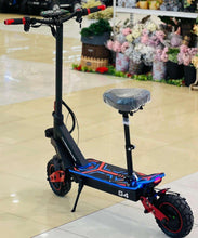 Electric scooter full view with blue deck, red wheel trim, and padded seat.