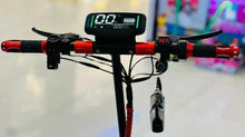 Electric scooter cockpit with central display, red handlebar stem, and front light