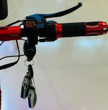 Electric scooter handlebar with red grips, digital display reading 507, and keys
