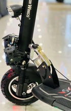 Electric scooter rear three-quarter view with suspension, deck, and black fender details