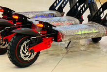 Electric scooter rear wheel and deck, red frame trim, lit tail lights, blue-gray deck