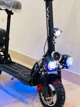 Black electric scooter close-up of front wheel and headlight with glowing blue lights