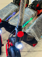 Electric scooter close-up with textured deck, front fork, bright headlight, LED panel