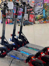 Electric scooter with textured deck, bright front lights, black frame, red accents