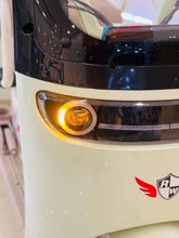 Electric tricycle front headlight with glowing amber light and front emblem