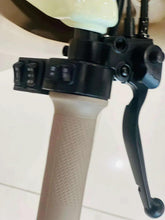 Handlebar lever controls of electric 3-wheel tricycle with black grips and beige frame