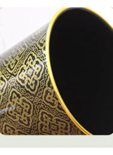 Trash can with gold patterned body and open black interior, gold-edged rim