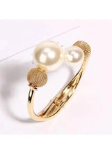 Gold-tone open cuff bracelet with textured mesh bead caps and three white pearls