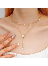 Gold-tone Y-shaped pearl necklace with three strands and round pearl drop details