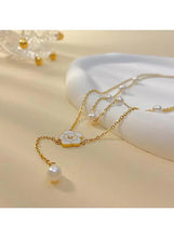 Gold-tone Y-shaped necklace with flower pendant and small pearl bead accents