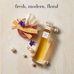 Elizabeth Arden 5th Avenue perfume bottle with fresh floral elements and pearls on a light background