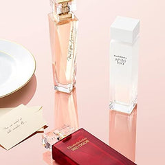 Elizabeth Arden 5th Avenue perfume bottle along with White Tea and Red Door fragrances on pink background