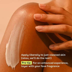 Person applying white body moisturizer cream to an arm with fingertips