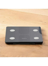 Smart body composition scale on wooden floor, eufy, four round sensor spots