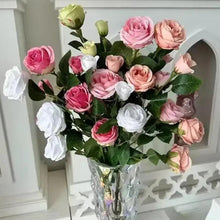 Multi-color faux rose bouquet in clear vase with green leaves