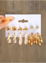 Gold-tone earring set on card: twisted studs, butterfly charms, crystal studs, and gold spiral hoops