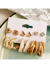 Gold-tone earring pack: twisted studs, butterfly charms, crystal studs, and pearl hoop drops