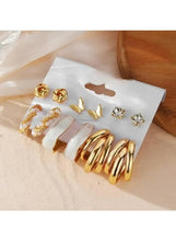 Gold-tone earring set: pearl cluster hoops, crystal studs, butterfly earrings, and gold spiral hoops
