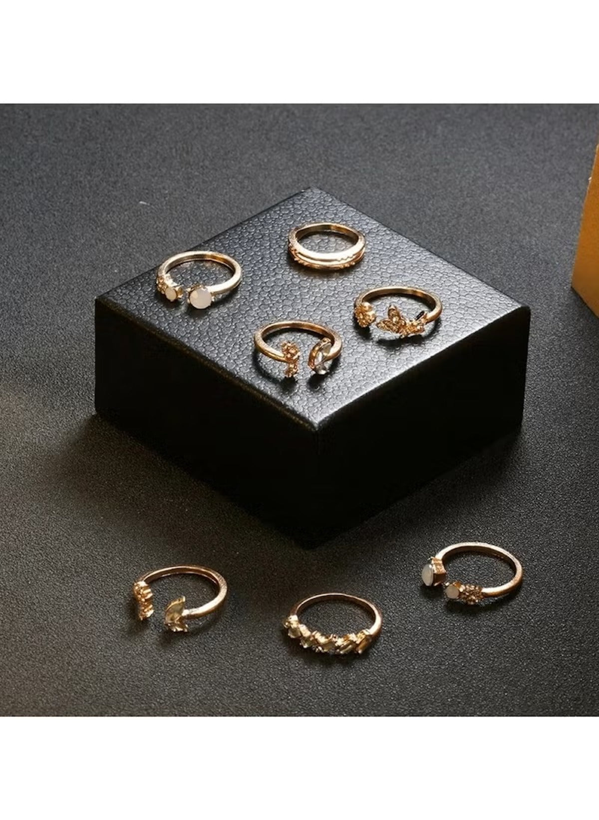 Huitich 7 piece fashion rings for girls in gold with various decorative designs displayed on black surface