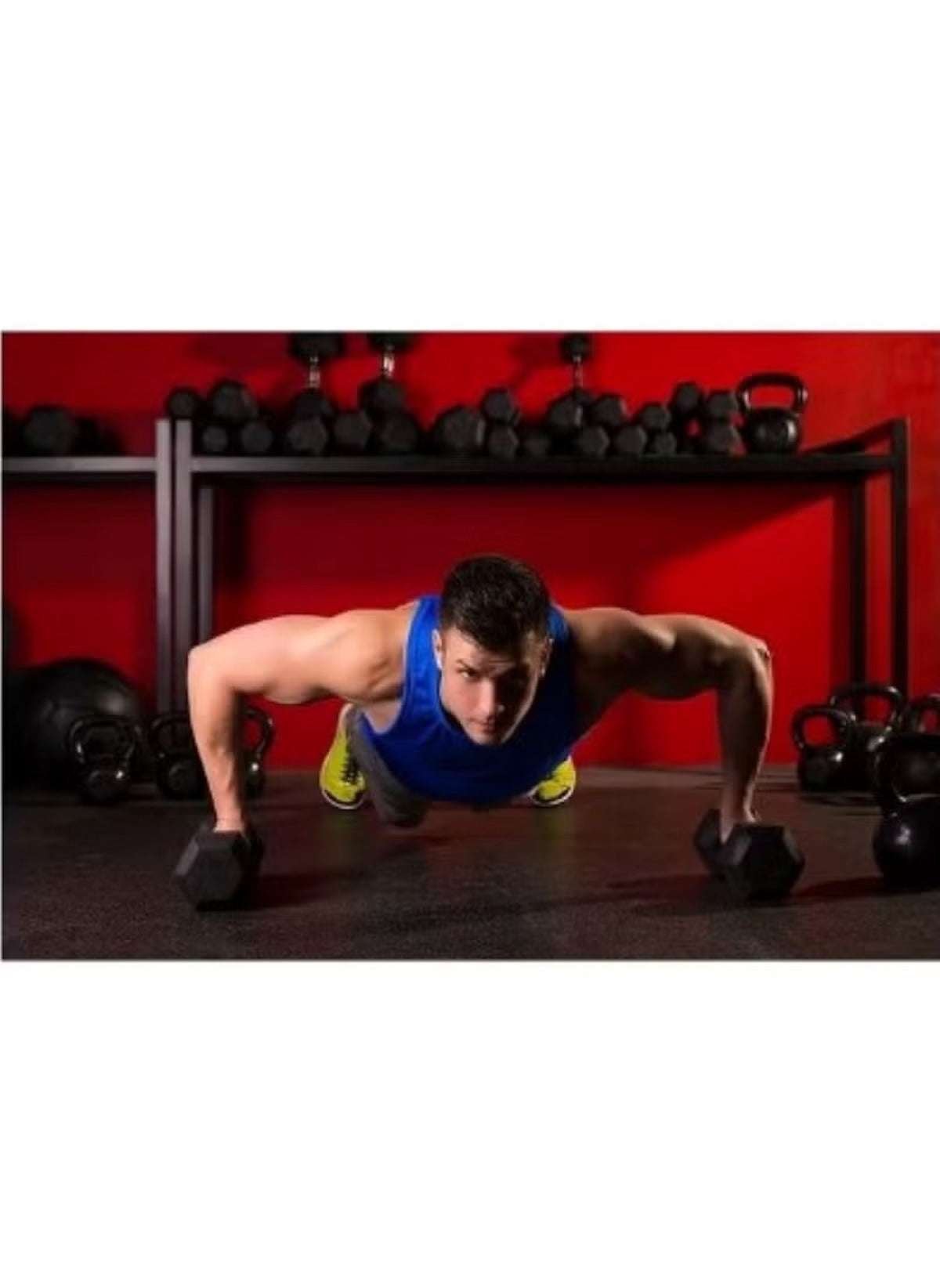 Man doing push-ups using 10kg strength training dumbbell in a gym with red wall background