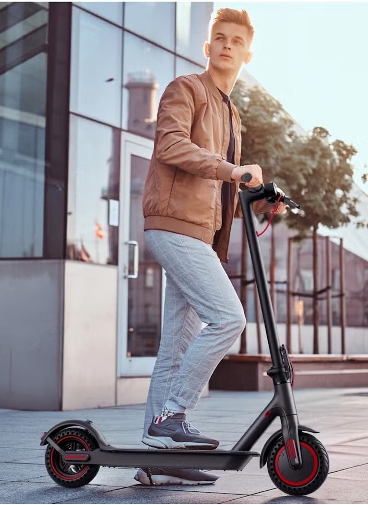 Young man riding Huitich foldable scooter 30km range in urban setting with modern buildings