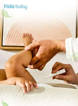 Caregiver using a white gas relief tube on a newborn's legs
