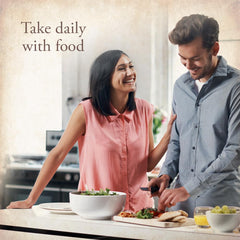 Couple preparing a healthy meal in kitchen with salad and text Take daily with food and Garden of Life multivitamin for women