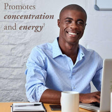 Smiling person working at a laptop with benefit text on the wall