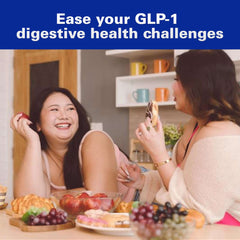 Two women laughing over brunch with fruit and pastries in a kitchen promoting Gas-X Maximum Strength gas relief softgels