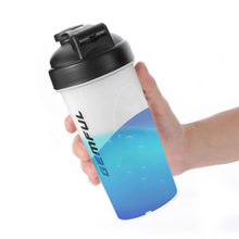 Shaker bottle held in hand, black flip lid, white body with blue lower section