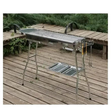 Outdoor charcoal grill with side shelves and cooking area on metal legs
