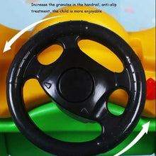 Black steering wheel detail on a yellow-and-green four-wheeled infant toy car
