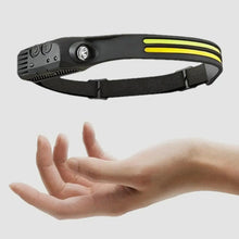 Rechargeable LED headlamp with black strap and yellow light bars, held near hand