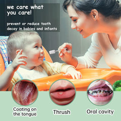 Mother cleaning infant in high chair with baby tongue cleaner soft gauze to prevent tooth decay