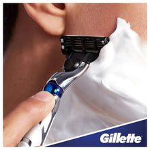Men's razor cartridge shaving a bearded area with white foam.