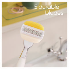 Gillette Venus and Olay razor refills close up showing razor head with yellow Olay bar and five blades over sink