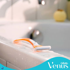 Gillette Venus disposable razor for women orange white razor resting on wet bathtub edge with logo
