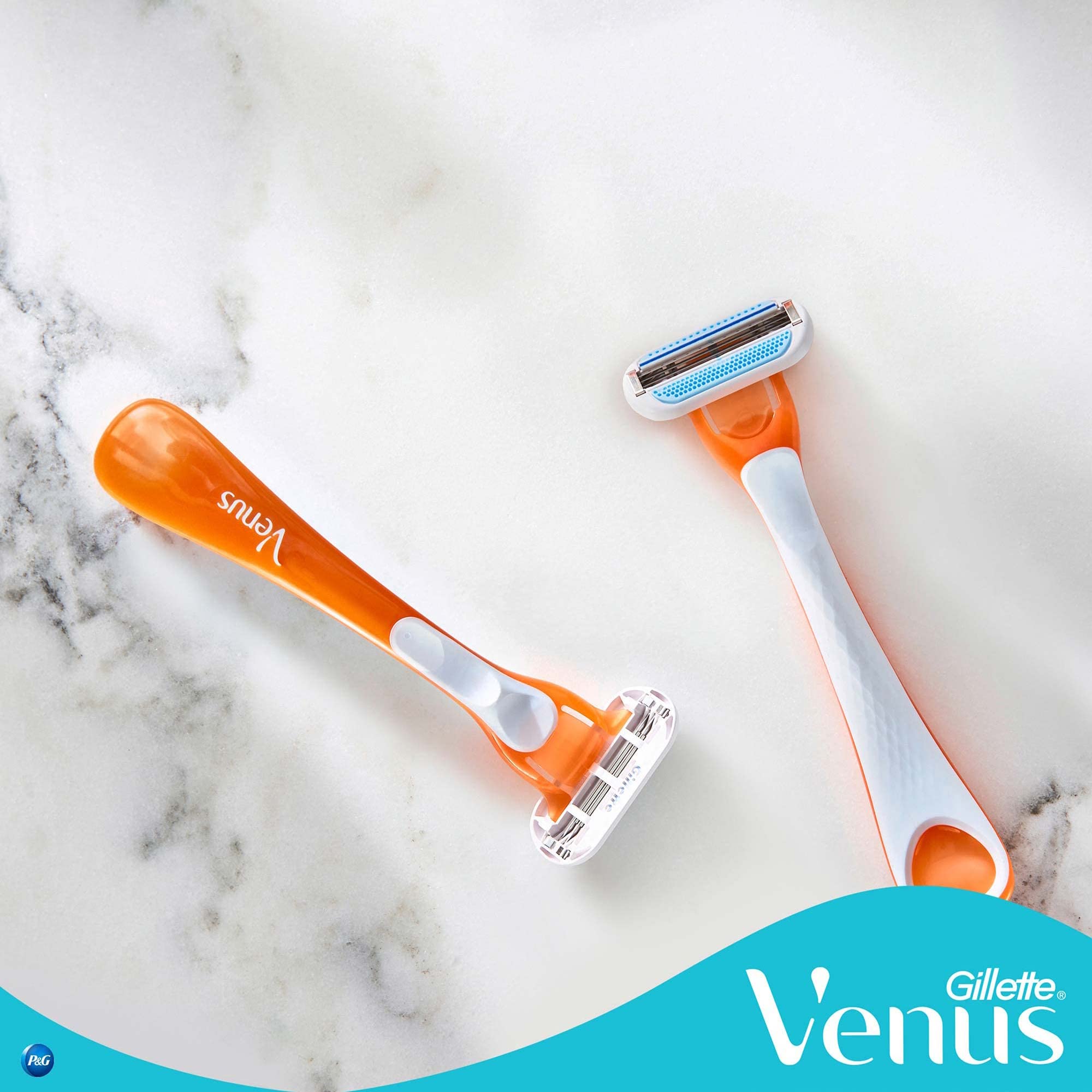 Two orange Gillette Venus disposable razor for women on marble surface showing double blade heads
