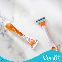 Disposable women’s razors with orange-and-white handles and 3-blade heads