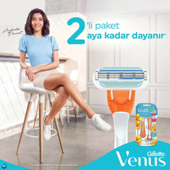 Smiling woman seated showing Gillette Venus disposable razor for women with close up razor head and floral twin pack packaging