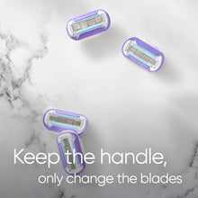 Set of razor blade refill cartridges with purple heads shown on a flat surface