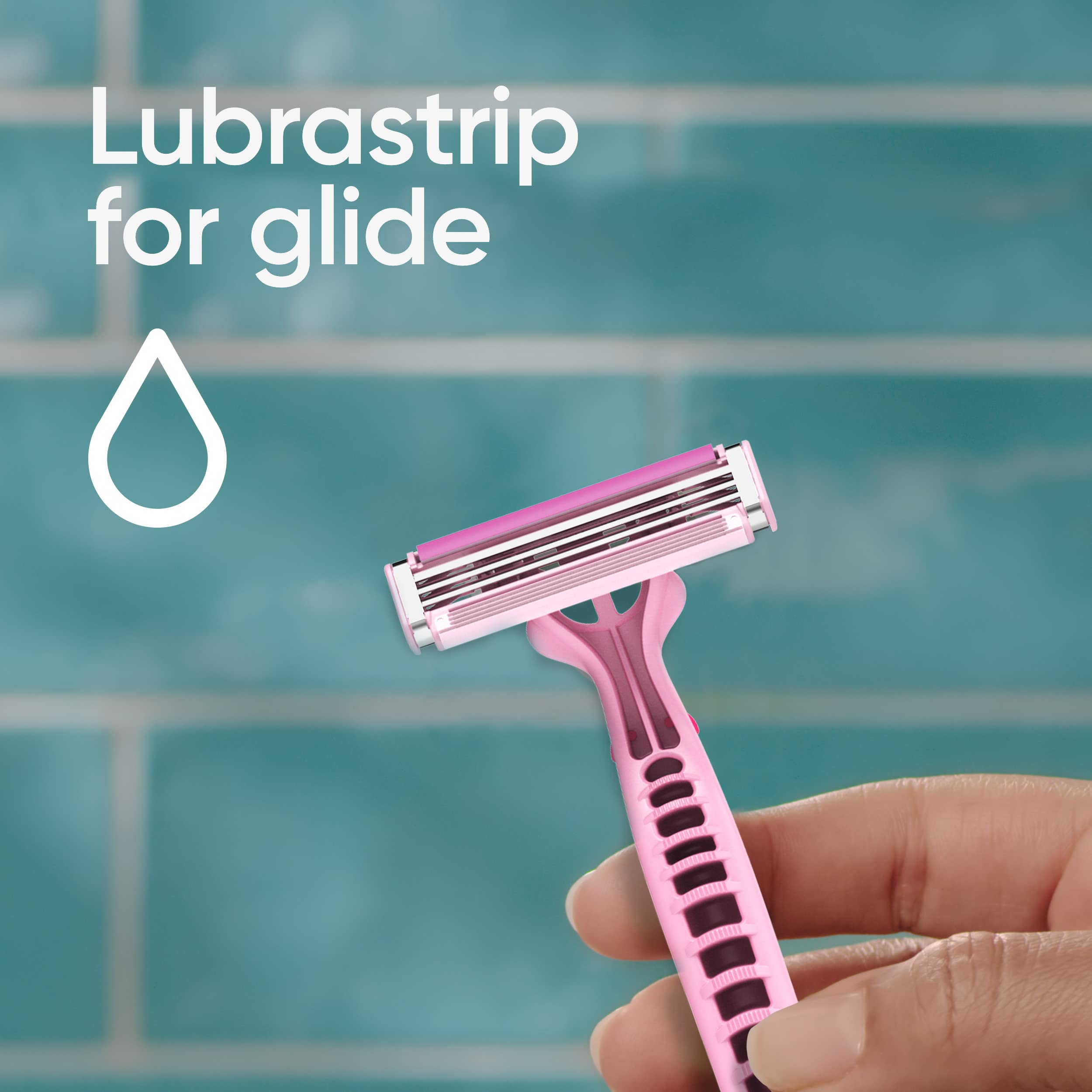 Hand holding pink Venus Simply 3 women's disposable razor with lubrastrip against teal tiles