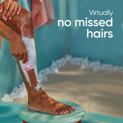 Woman shaving leg with pink Venus Simply 3 women's disposable razor and white shaving cream in teal bath